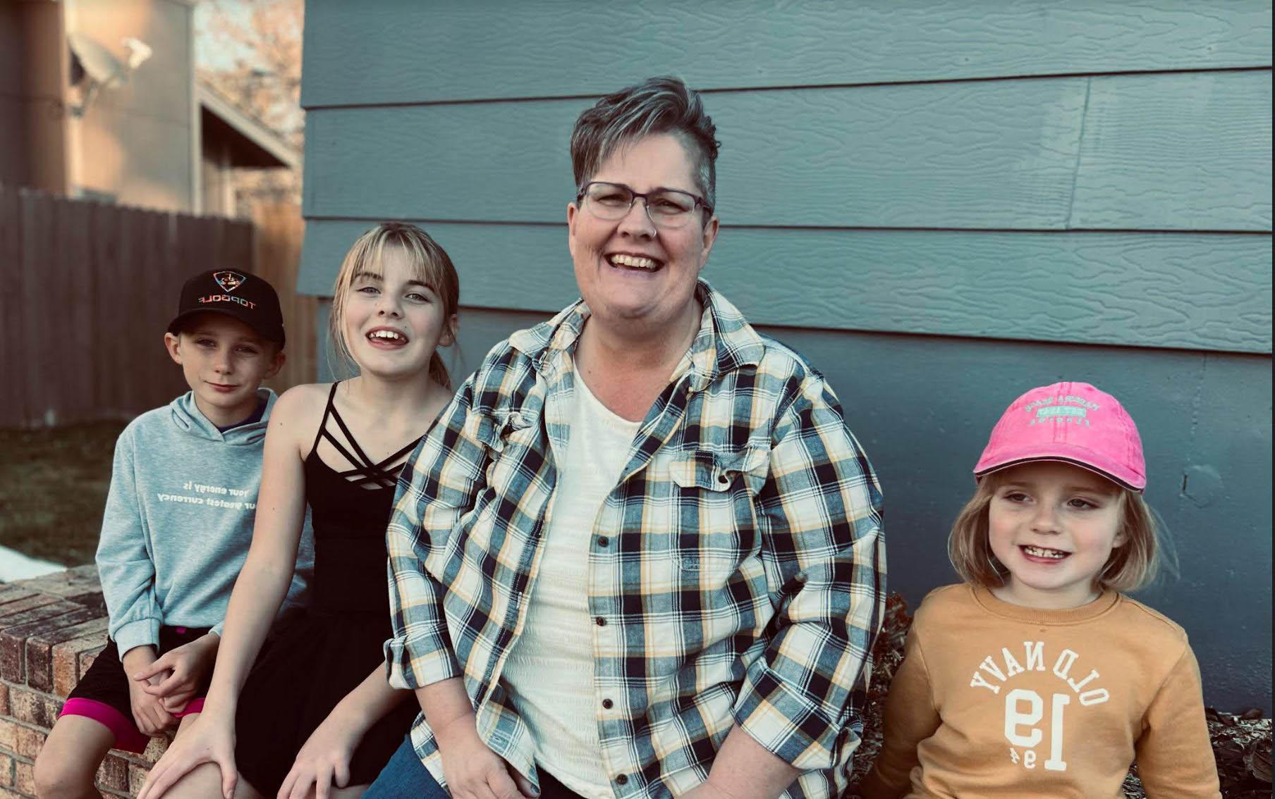 奥尔蒂斯 smiling with her three grandchildren.