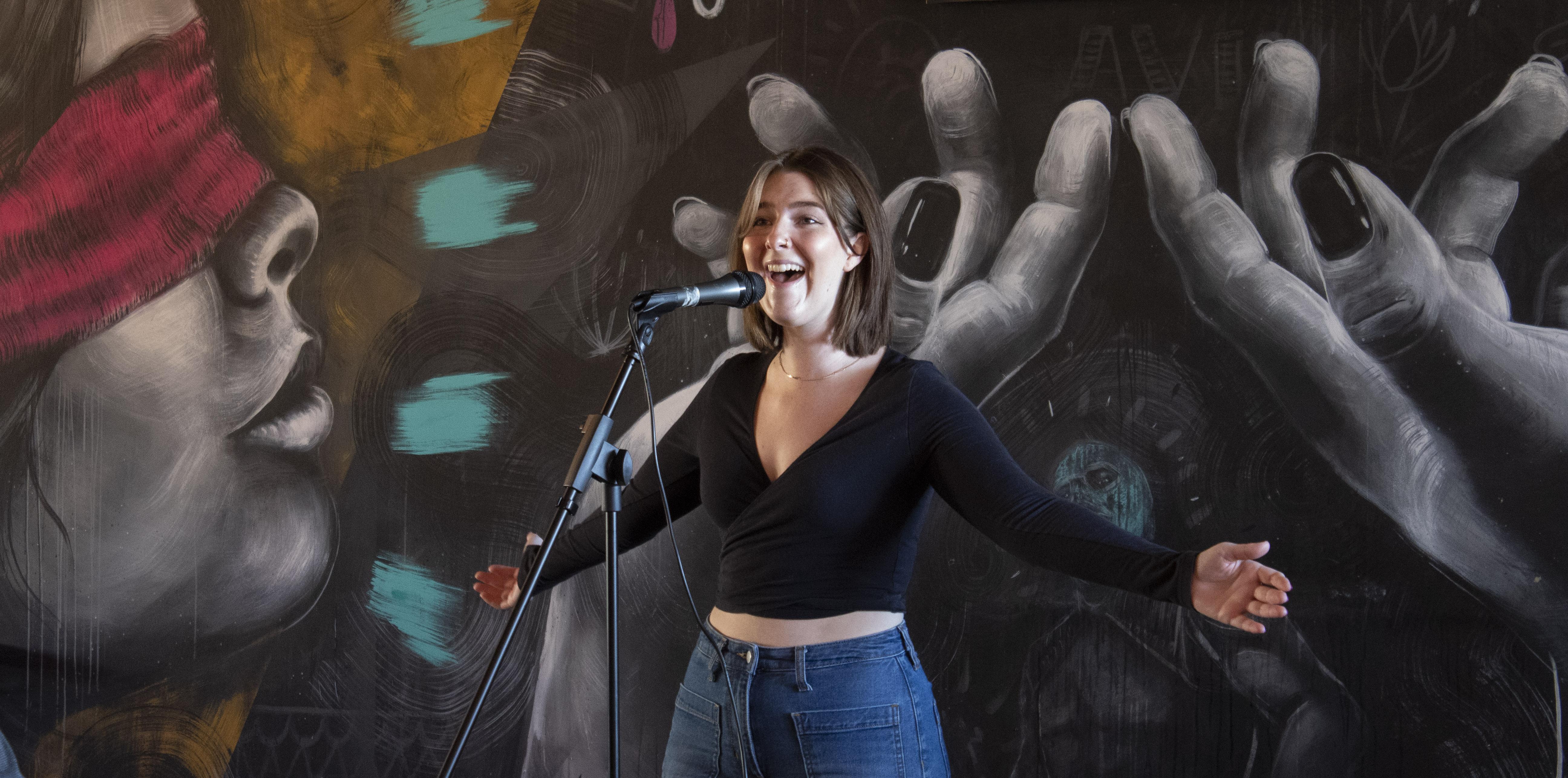 A student singing a song on stage