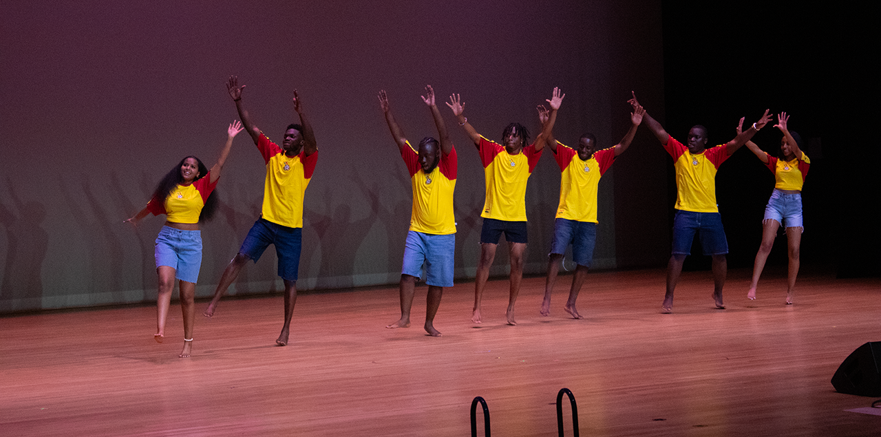 A group of men and women dancing together on stage